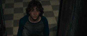 Movie still from “The Black Phone” (2021), directed by Scott Derrickson – A young man standing in a dark room; Close Up shot, High angle