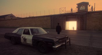 Movie still from “The Blues Brothers” (1980), directed by John Landis – A cop car parked in front of an open door; Wide shot, Over the shoulder angle