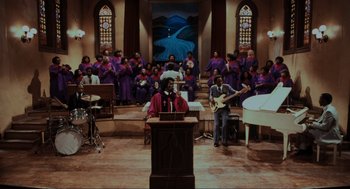 Movie still from “The Blues Brothers” (1980), directed by John Landis – A group of people standing in a room with instruments; Extreme Wide shot, High angle