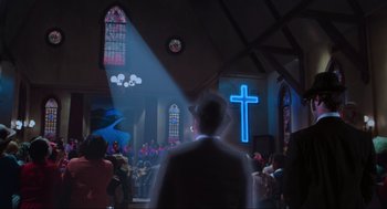 Movie still from “The Blues Brothers” (1980), directed by John Landis – A man standing in front of a cross in a church; Wide shot, Low angle