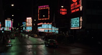 Movie still from “The Blues Brothers” (1980), directed by John Landis – Cars driving down a street at night in the dark; Extreme Wide shot, High angle
