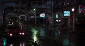 Movie still from “The Blues Brothers” (1980), directed by John Landis – A man walking down the street in the rain at night; Extreme Wide shot, High angle
