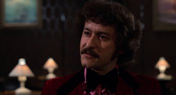 Movie still from “The Blues Brothers” (1980), directed by John Landis – A person wearing a suit and a bow tie; Close Up shot, Low angle