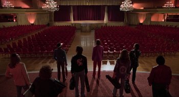 Movie still from “The Blues Brothers” (1980), directed by John Landis – A group of people standing in front of an empty theater; Wide shot, Low angle