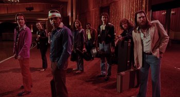 Movie still from “The Blues Brothers” (1980), directed by John Landis – A group of men and women standing in a room; Wide shot, High angle