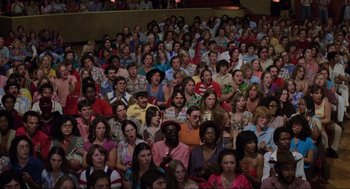 Movie still from “The Blues Brothers” (1980), directed by John Landis – A large group of people sitting in a room; Wide shot, High angle
