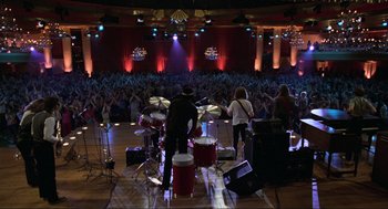 Movie still from “The Blues Brothers” (1980), directed by John Landis – A group of people playing drums in front of an audience; Extreme Wide shot, High angle