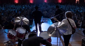 Movie still from “The Blues Brothers” (1980), directed by John Landis – A group of men playing drums in front of an audience; Wide shot, High angle