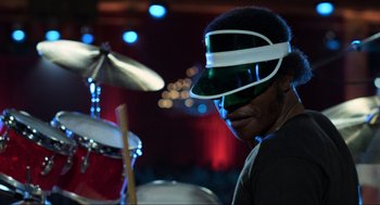 Movie still from “The Blues Brothers” (1980), directed by John Landis – A man with a visor on his head is playing a drum set; Close Up shot, Low angle