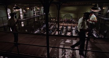 Movie still from “The Blues Brothers” (1980), directed by John Landis – A group of people sitting at tables in a large room; Extreme Wide shot, High angle