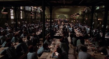 Movie still from “The Blues Brothers” (1980), directed by John Landis – A group of people sitting at a table with plates of food; Extreme Wide shot, High angle