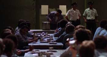 Movie still from “The Blues Brothers” (1980), directed by John Landis – A group of people sitting at a table with food; Wide shot, High angle