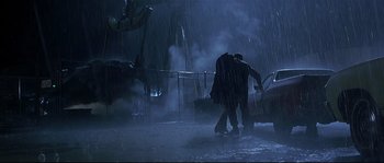 Movie still from “Con Air” (1997), directed by Simon West – Two people walking in the rain in the rain; Wide shot, Low angle