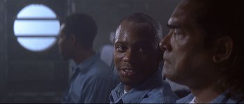 Movie still from “Con Air” (1997), directed by Simon West – A person wearing a blue shirt; Close Up shot, Over the shoulder angle