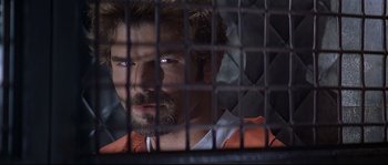 Movie still from “Con Air” (1997), directed by Simon West – A person behind a fence; Close Up shot, Over the shoulder angle