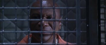 Movie still from “Con Air” (1997), directed by Simon West – A person behind a fence; Close Up shot, High angle