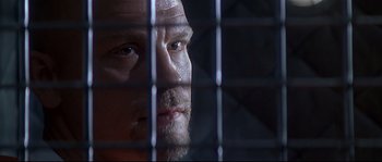 Movie still from “Con Air” (1997), directed by Simon West – A person behind a fence; Close Up shot, Low angle