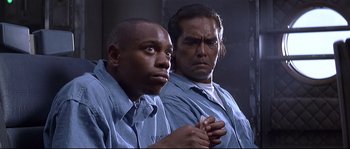 Movie still from “Con Air” (1997), directed by Simon West – A couple of men standing next to each other; Close Up shot, Over the shoulder angle