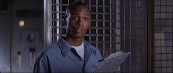 Movie still from “Con Air” (1997), directed by Simon West – A man holding a clipboard in front of a cage; Close Up shot, Low angle