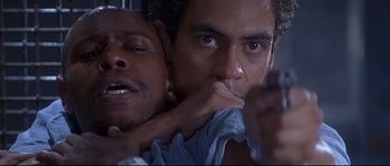 Movie still from “Con Air” (1997), directed by Simon West – A man holding another man in his arms; Close Up shot, Low angle