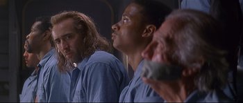 Movie still from “Con Air” (1997), directed by Simon West – A group of men standing next to each other in a room; Close Up shot, Low angle