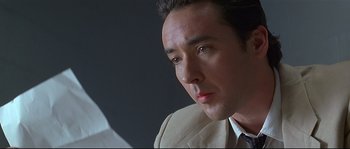 Movie still from “Con Air” (1997), directed by Simon West – A person wearing a suit and tie; Close Up shot, Low angle