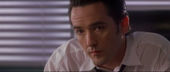 Movie still from “Con Air” (1997), directed by Simon West – A person wearing a shirt and tie; Close Up shot, Low angle