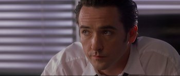 Movie still from “Con Air” (1997), directed by Simon West – A person wearing a shirt and tie; Close Up shot, Low angle