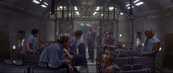 Movie still from “Con Air” (1997), directed by Simon West – A group of men sitting on top of a train; Wide shot, High angle