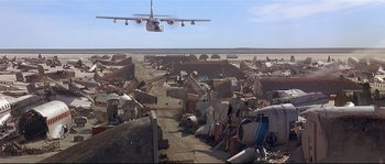 Movie still from “Con Air” (1997), directed by Simon West – An airplane is flying over an abandoned airfield; Extreme Wide shot, Low angle