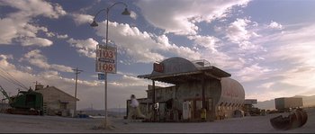 Movie still from “Con Air” (1997), directed by Simon West – An old gas station on the side of the road; Extreme Wide shot, Low angle