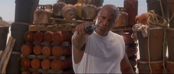 Movie still from “Con Air” (1997), directed by Simon West – A man holding a cell phone in his hand; Close Up shot, Low angle