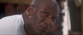 Movie still from “Con Air” (1997), directed by Simon West – A bald man's face; Close Up shot, Low angle