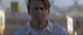 Movie still from “Con Air” (1997), directed by Simon West – A person wearing a white shirt; Close Up shot, Low angle