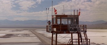 Movie still from “Con Air” (1997), directed by Simon West – A man standing on top of a platform; Extreme Wide shot, Low angle