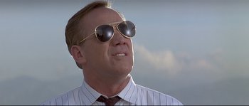 Movie still from “Con Air” (1997), directed by Simon West – A person wearing sunglasses and a tie; Close Up shot, Low angle