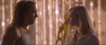 Movie still from “Con Air” (1997), directed by Simon West – A man and a woman standing next to each other in front of lights; Close Up shot, Low angle