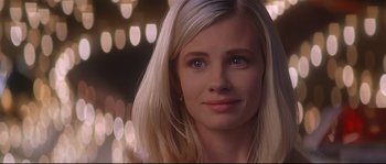 Movie still from “Con Air” (1997), directed by Simon West – A woman with blonde hair and blue eyes looking at the camera; Close Up shot, Over the shoulder angle
