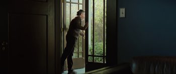 Movie still from “The Boogeyman” (2023), directed by Rob Savage – A man standing in front of an open door; Medium shot, Low angle