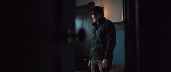 Movie still from “The Boogeyman” (2023), directed by Rob Savage – A man standing in front of a mirror in a dark room; Medium shot, Over the shoulder angle