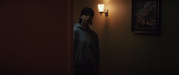 Movie still from “The Boogeyman” (2023), directed by Rob Savage – A person standing next to a light in a room; Medium shot, Over the shoulder angle
