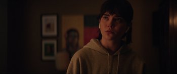 Movie still from “The Boogeyman” (2023), directed by Rob Savage – A woman in a hooded sweatshirt stares into the camera; Close Up shot, Over the shoulder angle