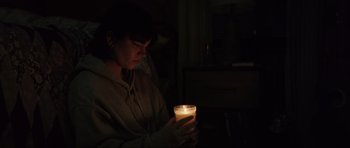 Movie still from “The Boogeyman” (2023), directed by Rob Savage – A person holding a candle in a dark room; Medium shot, Over the shoulder angle