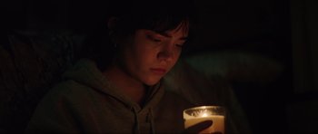 Movie still from “The Boogeyman” (2023), directed by Rob Savage – A person looking at a candle in a dark room; Close Up shot, Low angle