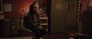 Movie still from “The Boogeyman” (2023), directed by Rob Savage – A girl sitting on a chair in a room; Medium shot, Over the shoulder angle