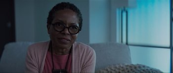 Movie still from “The Boogeyman” (2023), directed by Rob Savage – An older black woman wearing glasses and a pink sweater; Close Up shot, Over the shoulder angle