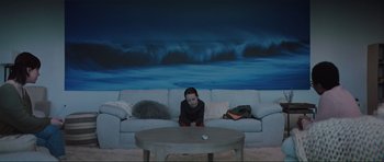 Movie still from “The Boogeyman” (2023), directed by Rob Savage – A woman sitting on a couch in a living room; Wide shot, High angle