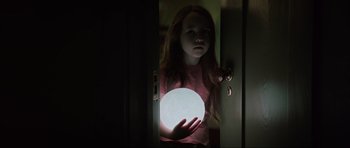 Movie still from “The Boogeyman” (2023), directed by Rob Savage – A young girl holding a glowing ball in her hands; Medium shot, Low angle