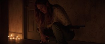 Movie still from “The Boogeyman” (2023), directed by Rob Savage – A woman sitting on the ground holding a skateboard; Medium shot, High angle
