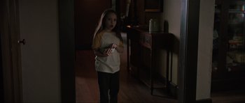 Movie still from “The Boogeyman” (2023), directed by Rob Savage – A little girl standing in a dark room holding a wii remote; Medium shot, High angle